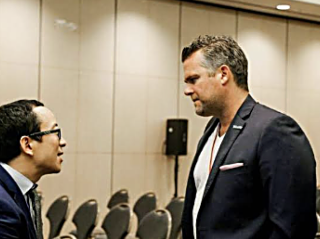 William Skelley talking with an attendee at a conference